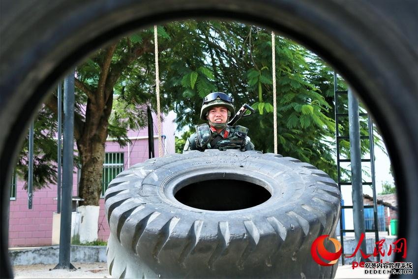 一名武警官兵在進行翻動重卡外輪胎訓練，重達300多斤的輪胎每次一翻動都需要拼盡全力。